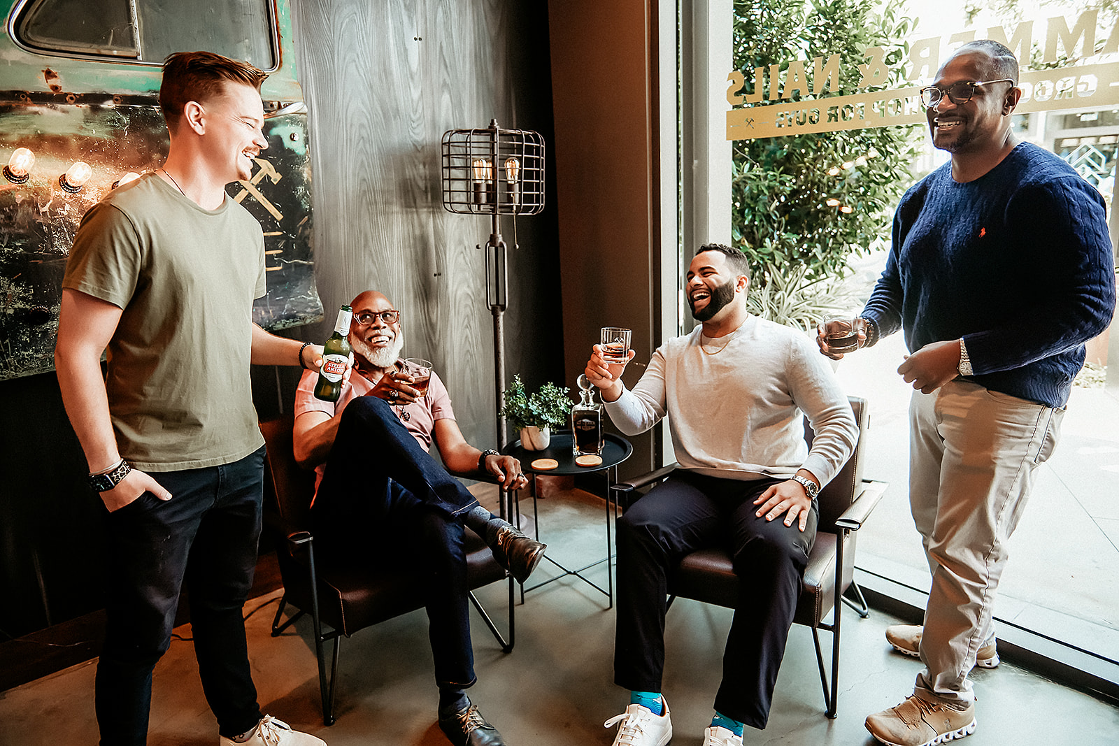 Members enjoying beverages inside a Hammer & Nails lounge